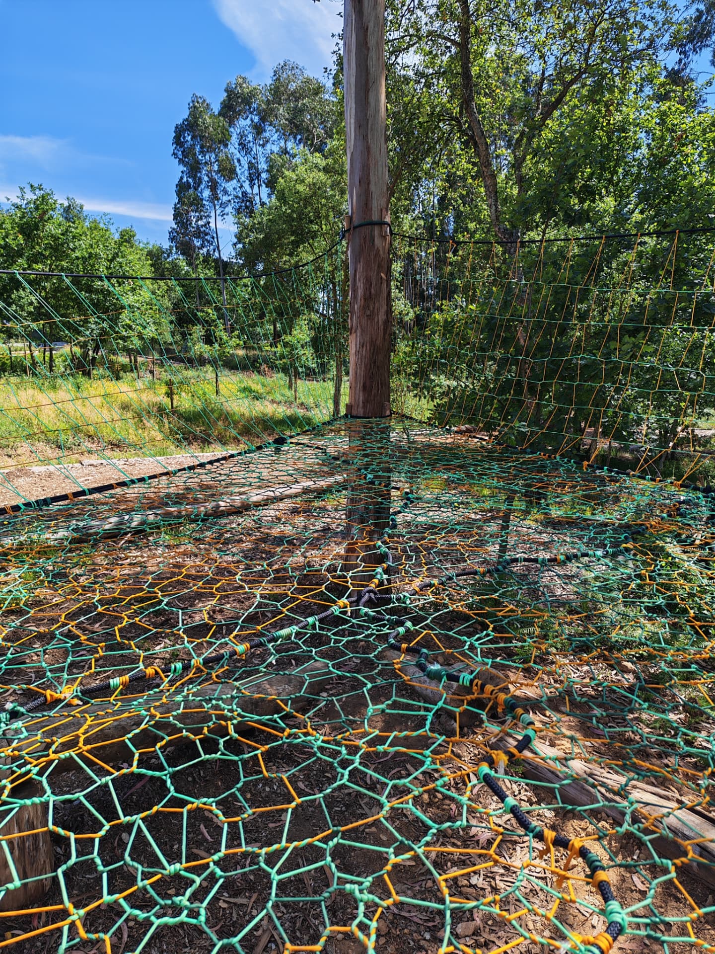Detail of the woven green and orange net panels and rope edging of the Portugal TreeNet